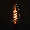 A close-up shot of a clear, filament LED candle light bulb with a spiral filament, glowing with warm orange light against a black background. Produktbild-Vorschau