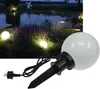 A garden pond illuminated by globe lights at dusk. Produktbild-Vorschau