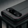 A close-up shot of a black leather phone case with red stitching, showing the camera cutout. Produktbild-Vorschau