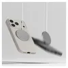 A beige phone case with a magnetic charging accessory attached, suspended by white cords against a light gray background. Another magnetic accessory is blurred in motion to the right. Produktbild-Vorschau