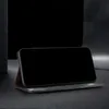 A smartphone in a flip case, propped up on a dark surface. Produktbild-Vorschau
