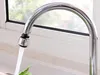 Water flowing from a faucet with an adapter attached, in front of a window. Produktbild-Vorschau