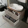 A modern bathroom vanity with a sink and open drawers showing towels and toiletries. Produktbild-Vorschau