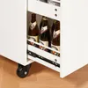A close-up view of a white kitchen cart with bottles of beer in a pull-out drawer. Produktbild-Vorschau
