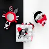 Three baby toys arranged on a black and white background. Produktbild-Vorschau