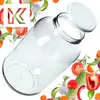 A clear glass jar with a white lid, surrounded by various fresh vegetables and herbs. Podgląd zdjęcia produktu