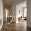 A drying rack with towels is placed in a hallway, with a living room visible through an archway. Produktbild-Vorschau