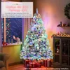 A decorated Christmas tree in a living room setting, with gifts underneath and a window view of Christmas lights. Voir les images du produit