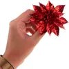 A hand holding a red glitter poinsettia decoration. Produktbild-Vorschau