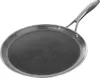 A close-up, studio shot of a round, flat frying pan with a textured surface and a long handle, set against a white background. Voir les images du produit