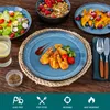 A table setting with various dishes and tableware, including plates, bowls, and cutlery, arranged on a wooden surface. Náhled obrázku produktu