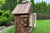 A wooden smoker in a garden setting. Produktbild-Vorschau