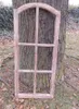 A wooden window frame leaning against a tree trunk outdoors. Produktbild-Vorschau