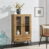 A wooden display cabinet with glass doors and drawers, placed in a room with a white brick wall and a chair. Anteprima dell’immagine prodotto