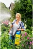 A woman is using a garden sprayer in a lush garden. Produktbild-Vorschau