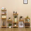 A collection of SONGMICS shelving units with various decorative items and plants displayed on them, set against a plain wall. Produktbild-Vorschau