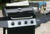 A gas grill is shown in an outdoor setting with a pool and patio furniture in the background. Produktbild-Vorschau