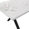 A close-up view of a white marble-patterned tabletop with black metal legs of a dining table. Náhľad obrázku produktu
