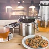 A tea set with a storage container, a teapot, a cup of tea, and cookies on a wooden table. Anteprima dell’immagine prodotto