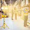 People working in a warehouse with a portable LED work light. Produktbild-Vorschau