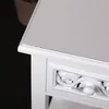 Close-up of the corner of a white vintage-style side table with a drawer. Náhled obrázku produktu