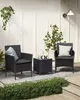 A black rattan furniture set with two chairs and a table on a patio. Produktbild-Vorschau