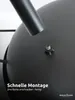 Close-up of a black metal fire pit with a screw attachment and a pipe, with text overlay. Produktbild-Vorschau
