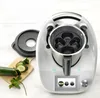 A kitchen appliance accessory is shown next to some sliced cucumber and parsley on a wooden cutting board. Produktbild-Vorschau