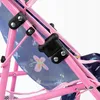 A close-up view of a pink doll stroller frame with blue fabric featuring a butterfly pattern. Produktbild-Vorschau