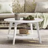 A white coffee table with decorative items on it, placed in a living room setting with a sofa in the background. Produktbild-Vorschau