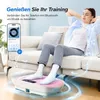 A woman is relaxing on a couch while using a vibration plate, with a phone displaying music controls nearby. Produktbild-Vorschau