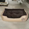 A dog bed is placed on a wooden floor in a room with a fireplace and flowers in the background. Náhľad obrázku produktu