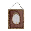 A decorative picture frame with an oval inset, hanging from a chain. Voir les images du produit