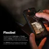 A person's hands are shown inserting a battery into the back of a rugged mobile phone, with text describing its features. Podgląd zdjęcia produktu