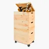 A stack of three wooden storage boxes with lids and wheels, with two teddy bears on top. Produktbild-Vorschau