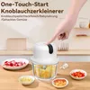 A hand is pressing a button on a white electric garlic chopper. Several small bowls with chopped ingredients are arranged around it. Produktbild-Vorschau