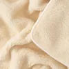 A close-up view of a fluffy, cream-colored blanket. Produktbild-Vorschau