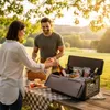 A couple is having a picnic in a park during sunset. Produktbild-Vorschau