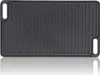 A top-down view of a black cast iron grill plate with raised ridges and handles on the sides, set against a white background with a reflection. Náhľad obrázku produktu