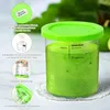 A close-up shot of a green lidded container filled with a green smoothie, surrounded by smaller circular images showcasing product features and compatibility. Produktbild-Vorschau