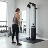 A woman is using a cable crossover machine in a gym. Produktbild-Vorschau