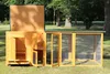 A wooden chicken coop with an attached run, set up outdoors on a grassy lawn with trees in the background. Produktbild-Vorschau