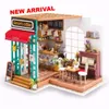 A miniature dollhouse cafe scene with a coffee shop front and interior. Anteprima dell’immagine prodotto