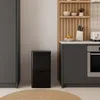 A modern kitchen scene with a black sensor trash can and cabinetry. Voir les images du produit