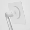 A close-up view of a white plastic air conditioner wind deflector attached to a clear adhesive square. Produktbild-Vorschau