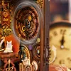 A detailed close-up of a miniature book nook with intricate clockwork and decorative elements. Voir les images du produit