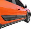 Close-up side view of an orange car with black protective trim on the doors and wheel arch. Náhľad obrázku produktu