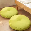 Two round floor cushions are placed on a wooden floor next to a modern coffee table. Produktbild-Vorschau