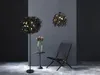 A modern living room scene with a floor lamp, a pendant light, a chair, and a small table with flowers. Voir les images du produit