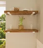 Two wooden shelves mounted on a textured wall, with a plant and a book on the top shelf. Produktbild-Vorschau